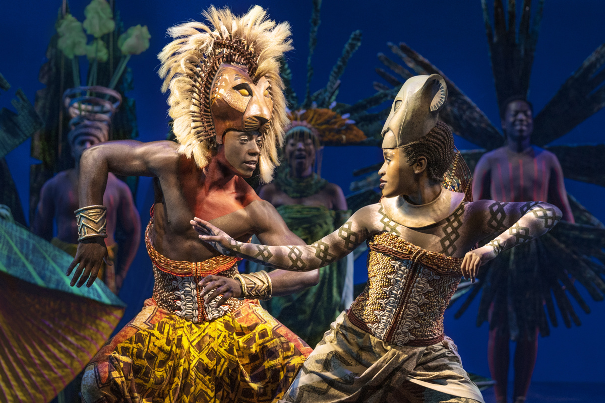 Brandon A. McCall as Simba and and Pearl Khwezi as Nala look at each other while dancing