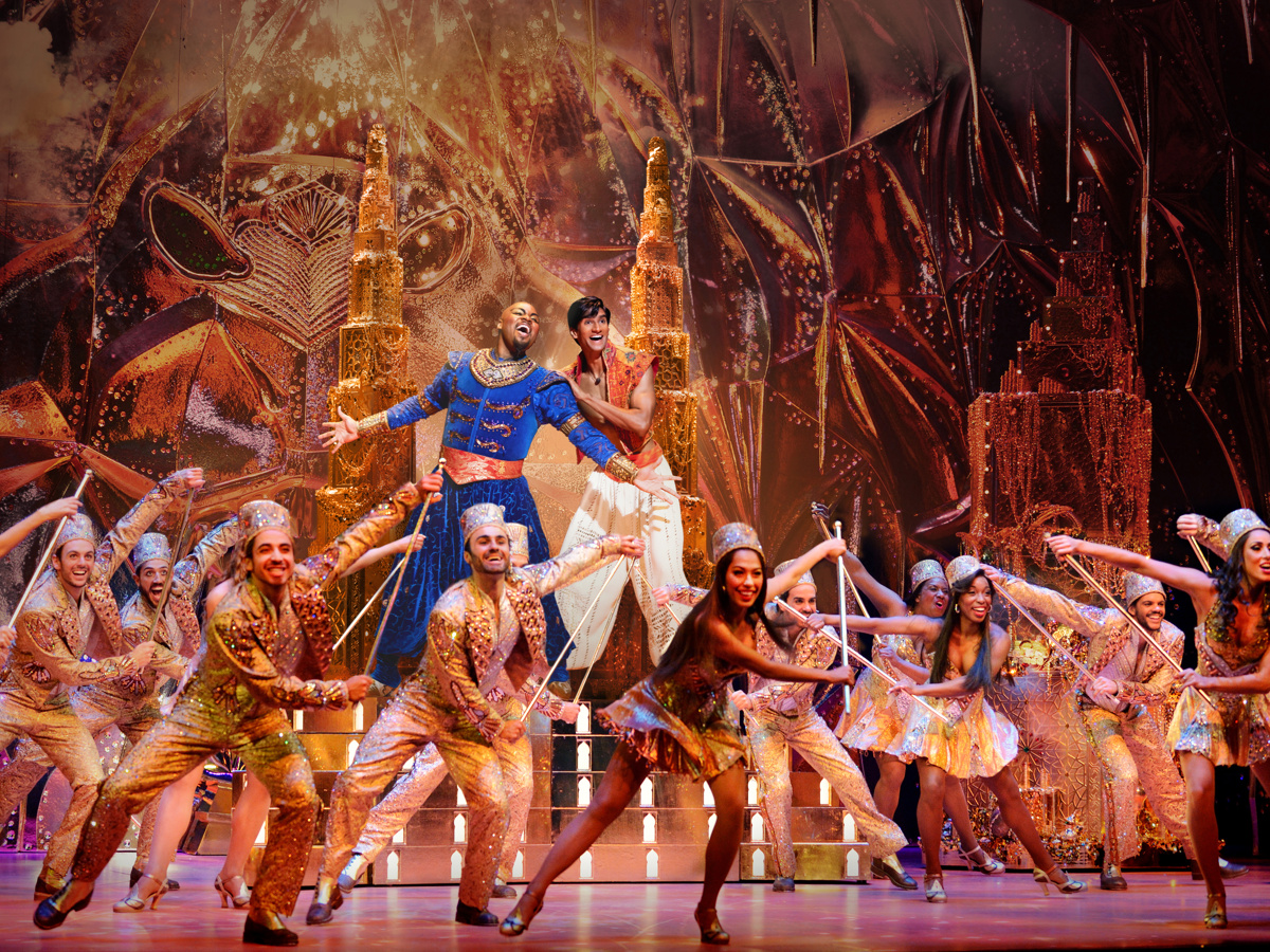 The cast of Aladdin dances on stage
