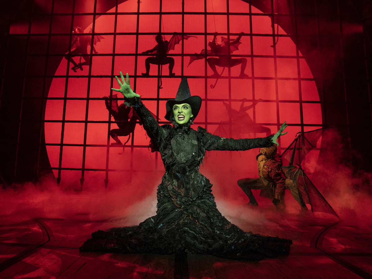 Elphaba dramatically facing forward with a red background