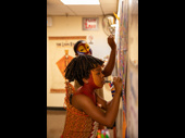 Albert Rhodes (Young Simba) and Nteliseng Nkhela (Rafiki) contribute some color to the cast's collective art piece backstage.